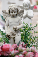 angel with floral wreath in hands on churchyard