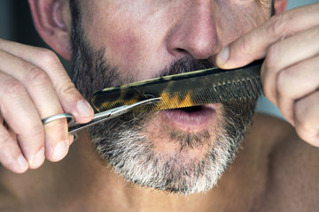 man trimming his beard