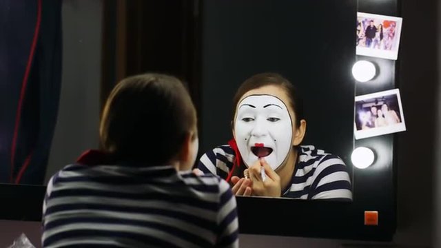 Woman mime lipstick in the mirror