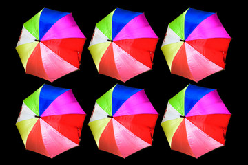 Colorful umbrellas isolated on black background.