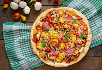 Pizza with salami, tomato, cheese and mushrooms. Top view