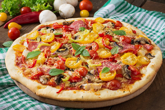Pizza with salami, tomato, cheese and mushrooms