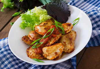 Delicious ravioli with tomato sauce and green onions