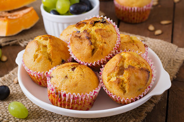 Appetizing and ruddy muffins with pumpkin and grapes
