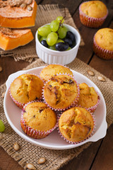 Appetizing and ruddy muffins with pumpkin and grapes