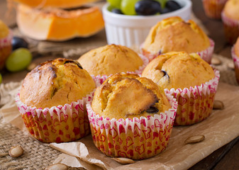 Appetizing and ruddy muffins with pumpkin and grapes