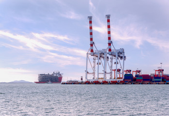 Fototapeta premium Container Cargo freight ship with working crane bridge in shipyard at Sunrise for Logistic Import Export background