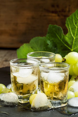 Cold grape juice with ice on dark background, selective focus