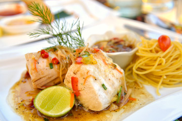 Steamed fish with spicy ginger sauce on white plate