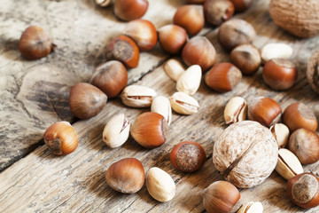 Walnuts, hazelnuts and pistachios on a wooden table, toned image