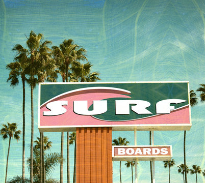 aged and worn vintage photo of surfboard sign with palm trees