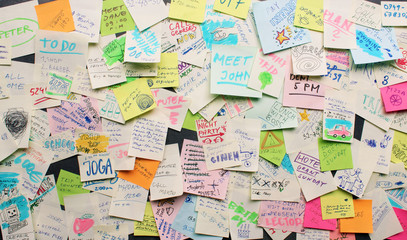 Post-it notes sticked chaotically on the wall - busy concept - Powered by Adobe