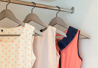 row of colorful dress hanging on coat hanger in white wardrobe