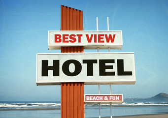 aged and worn vintage photo of hotel sign on beach