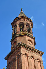 Fototapeta na wymiar torre con campanile e guglia piramidale