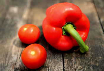 Tomaten und Paprika auf einem alten Holzbrett