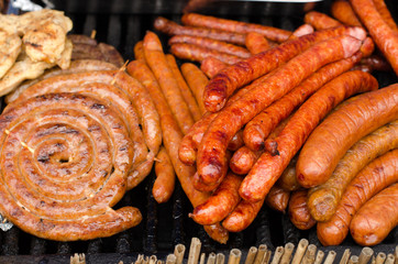 Delicious grilled meat with vegetable on a barbecue. Closeup of fried meat and sausages on a grill.