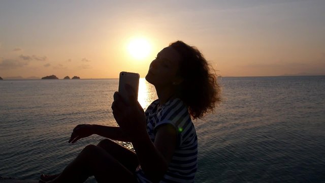 Young Woman Making Selfie with Mobile Phone at Sunset 
