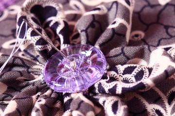 Patchwork cushion button.
Button on patchwork cushion with needle and thread.
