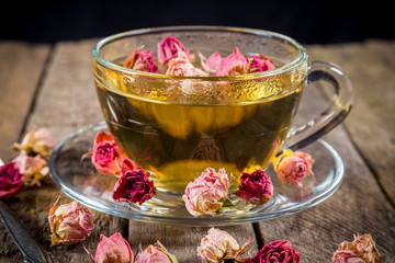 Closeup of green tea cup with dried rose buds