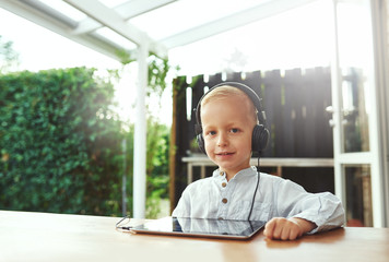 Cute smiling little boy listening to his music