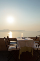 A sunset with the sea and a table is set for dinner