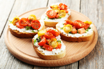 Tasty fresh bruschetta with tomatoes on cutting board on grey wo
