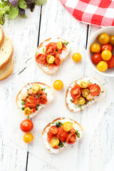 Tasty fresh bruschetta with tomatoes on white wooden background