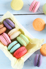 French colorful and tasty macarons in bowl on wooden table