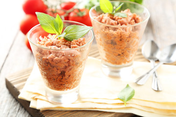 Glass with granita from fresh tomatoes on grey wooden background