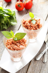 Glass with granita from fresh tomatoes on grey wooden background