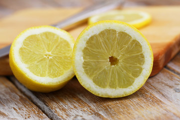 Half lemon leaning against wooden board
