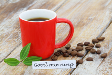 Good morning card with red mug of coffee and coffee beans on rustic surface

