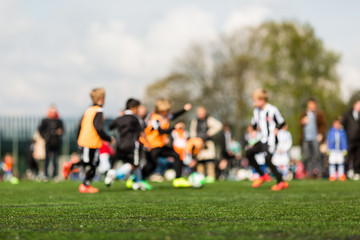 Obraz na płótnie Canvas Blurred young kids playing football