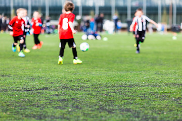 Obraz na płótnie Canvas Blurred young kids playing soccer