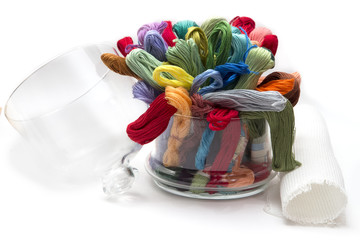 set of colored threads for embroidery, folded in a glass vase