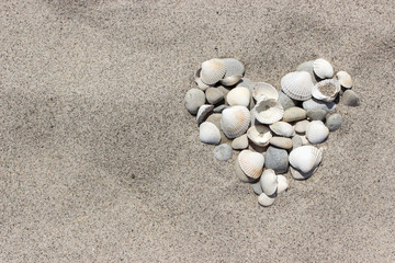 Fototapeta na wymiar Heart / Heart made of shells and pebbles in the sand 