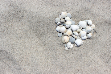 Fototapeta na wymiar Heart / Heart made of shells and pebbles in the san