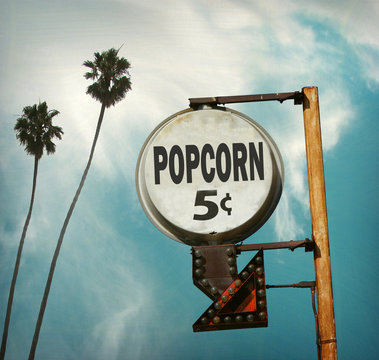aged and worn vintage photo of popcorn sign at drive in movies