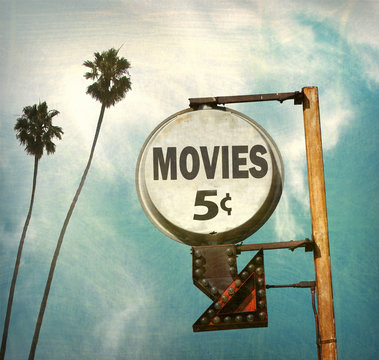 aged and worn vintage photo of movies sign with palm trees