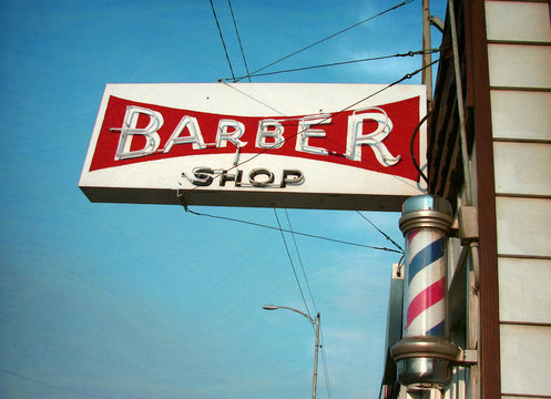 aged and worn vintage photo of neon barber shop sign