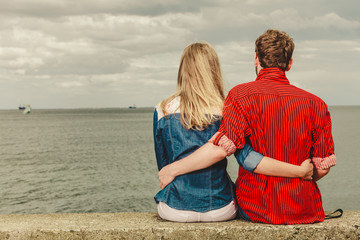 Couple sitting hugged on sea shore