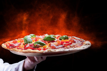 Pizza Heiß mit Flammen mit Hand Nahaufnahme