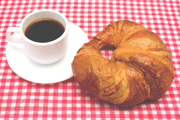 Coffee and croissant on table