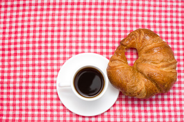 Coffee and croissant on table