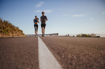 Obraz premium Two young people running on country road