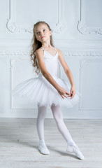 A little adorable young ballerina in a playful mood in the inter © jutaphoto