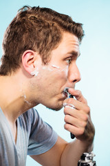 Man shaving with razor face profile