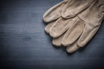 Fototapeta na wymiar leather working gloves on dark board