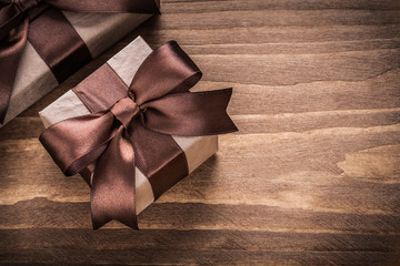 Wrapped present containers with brown ribbons on vintage wooden 